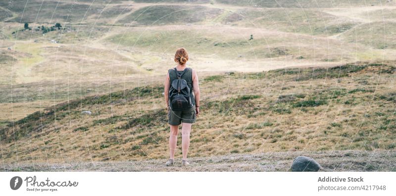 Unrecognizable traveling woman with backpack in mountains hiker traveler highland adventure admire hill female trekking scenery tourism trip wanderlust journey