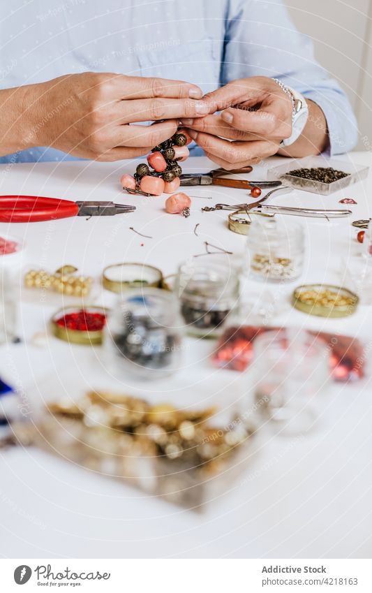 Woman making accessory with natural stones woman artisan necklace skill instrument workshop decorate adorn create female process designer bijouterie pincers