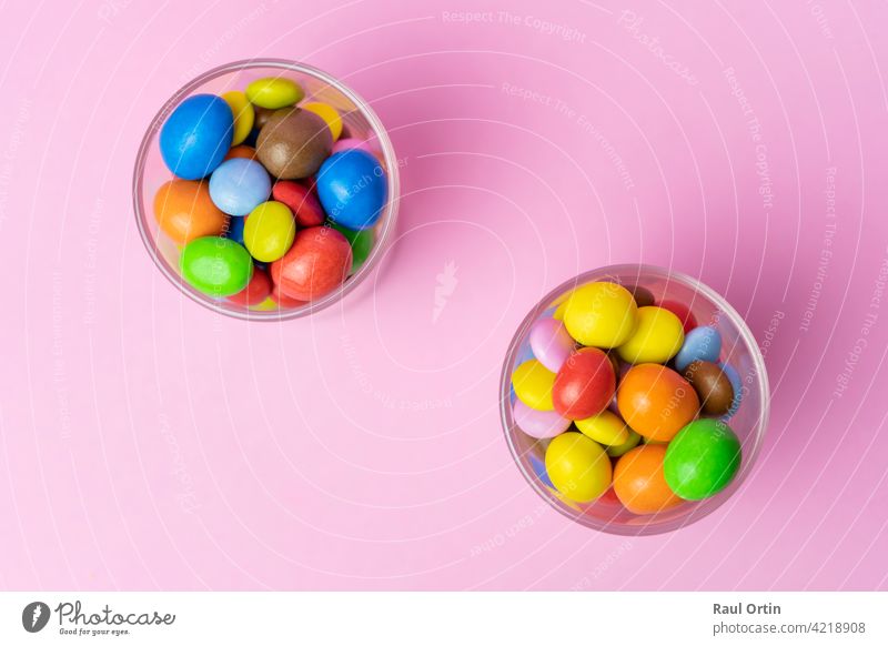 Multicolored chocolate candies in glass jar on blue vintage wooden background.Top view colorful sweets background concept with copy space for text. candy balls