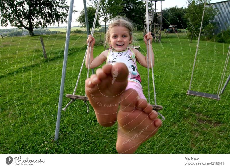 Girl swinging barefoot in the garden To swing Toddler Infancy Playing Swing Playground Movement Joie de vivre (Vitality) fun Smiling Laughter Summer Garden