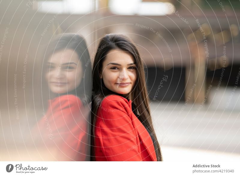 Cheerful woman in red clothes standing in city jacket outfit smile charming urban lean wall female cheerful street positive joy modern casual happy style