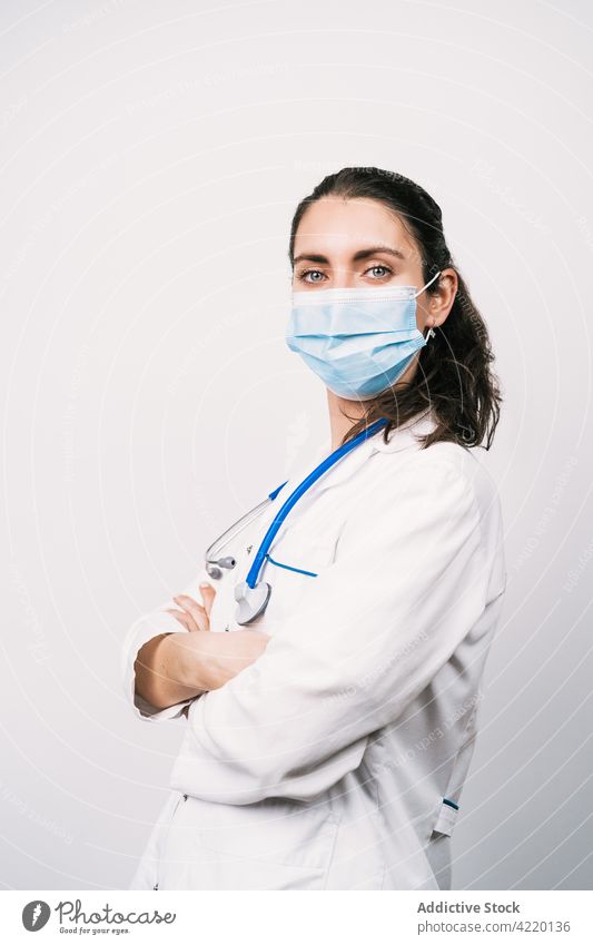 Confident physician in medical robe with crossed arms doctor arms crossed self assured uniform professional specialist protect health care woman portrait