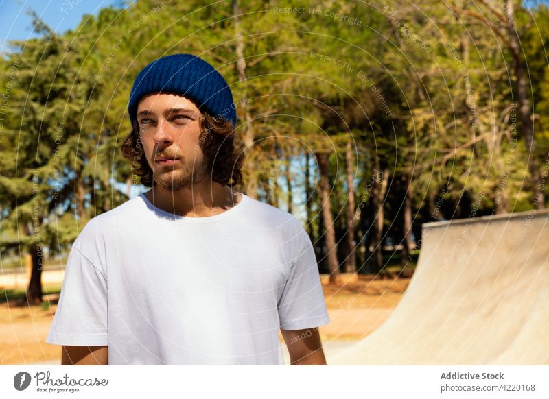Portrait of a young man with beard beanie portrait hat Young blue caucasian skating skate skateboard skatepark t-shirt skate park sport handsome urban attitude