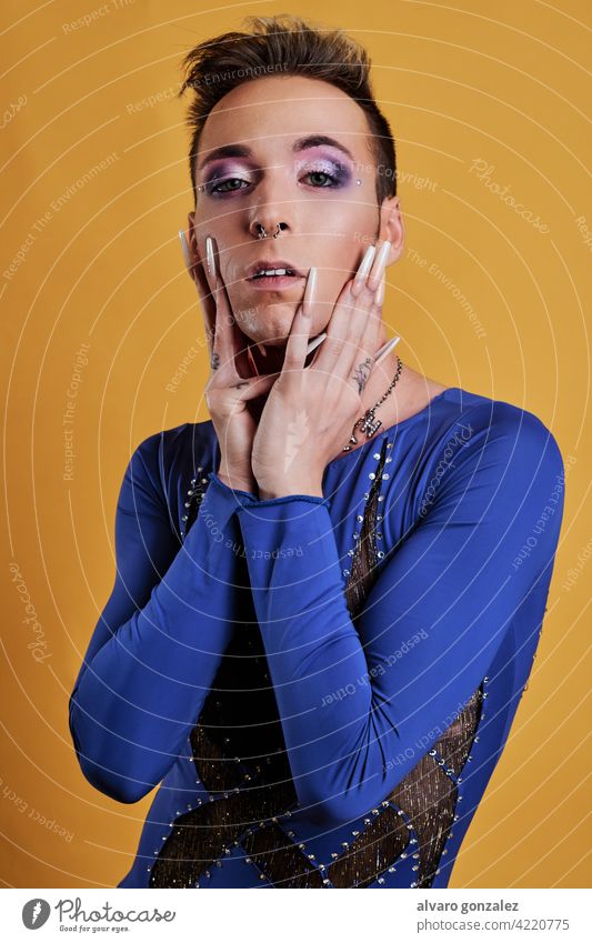 young transgender model with yellow background a blue dress che homosexual diversity feminine portrait guy make-up male person caucasian isolated white makeup