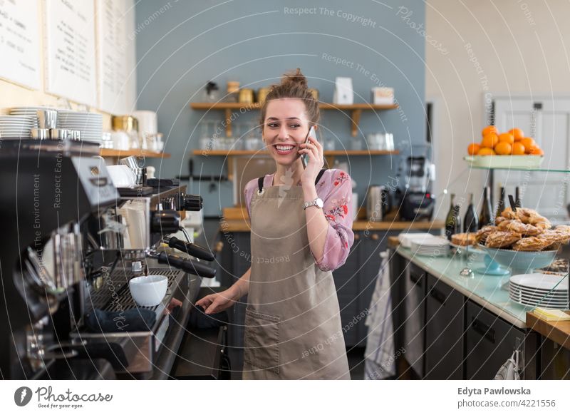 Young woman working in coffee shop people young adult casual attractive female smiling happy indoors Caucasian toothy enjoying cafe restaurant apron business