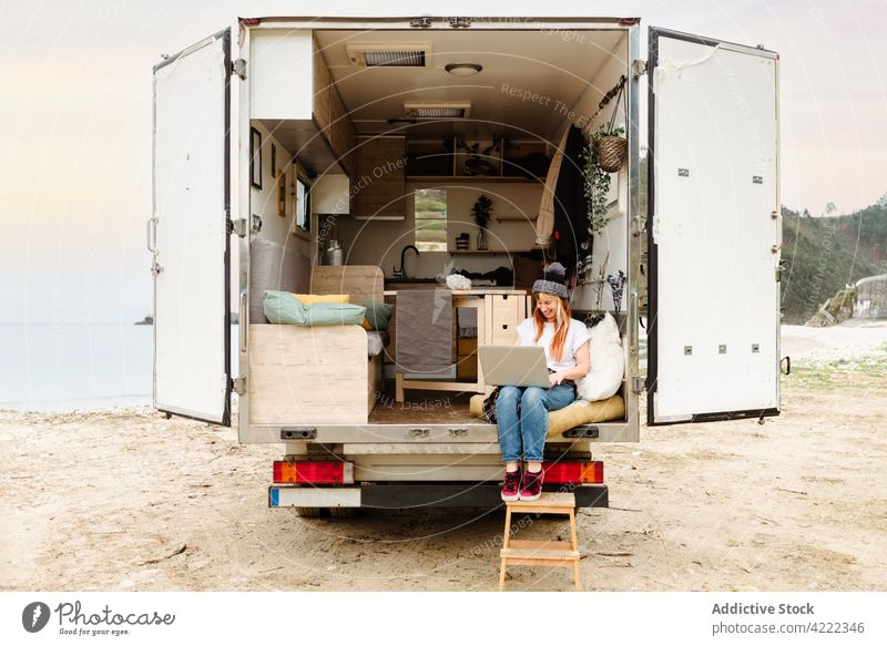 Smiling traveling woman using laptop van smile traveler female hipster cheerful delight enjoy happy talk positive device gadget vacation truck car automobile