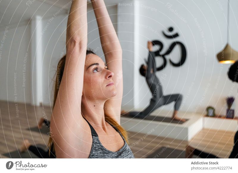 Conentrated women practicing yoga in a group, meditating with arms  interlaced Stock Photo by ©zzzdim 489108116