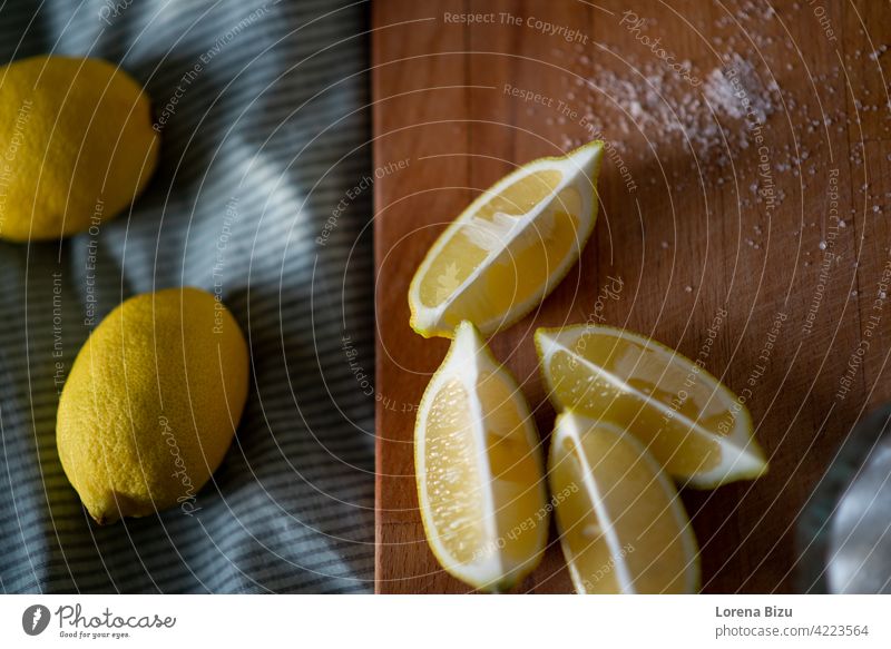 Full lemons and half lemons on a cutting board quarter lemons Cutboard Cut lemon Lemon and sugar Lemons Fruit Yellow Sour Fresh fruits Citrus fruits