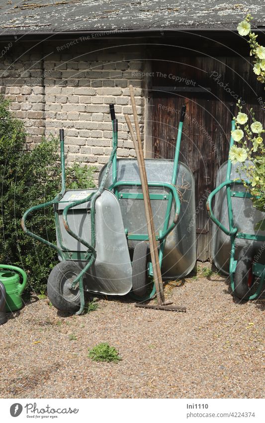 three wheelbarrows, a rake, a chopper and 2 watering cans are off duty Gardening equipment work facilitation Wheelbarrow Rake Häcker Watering can Closing time