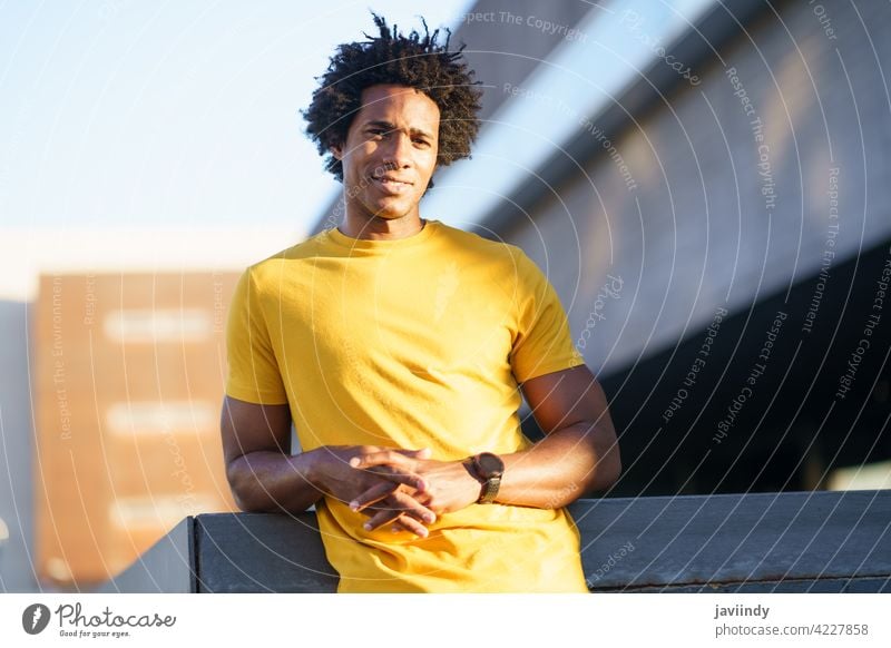 Black man with afro hair taking a break after workout. fitness black rest effort runner exercise jogger training male sport outside copyspace guy young park