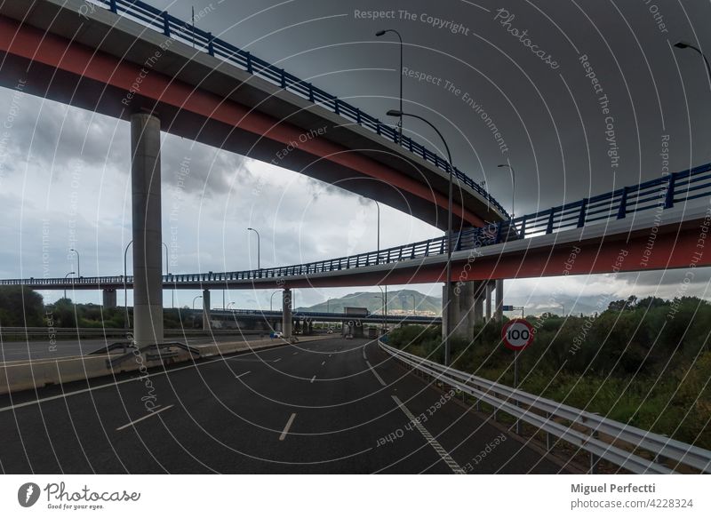 Several bridges crossing a highway with a cloudy sky. road architecture travel structure infrastructure traffic transport city dusk transportation urban steel