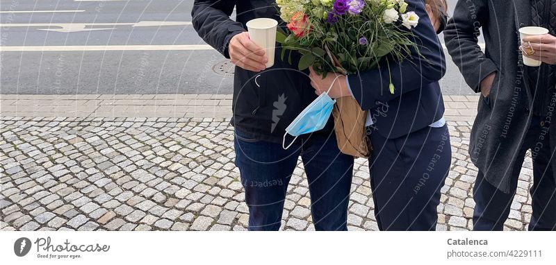Detail of three people, bouquet of flowers, paper cup, surgical mask, cobblestones and street Bouquet Operating mask Paper cup Cobblestones persons Town urban