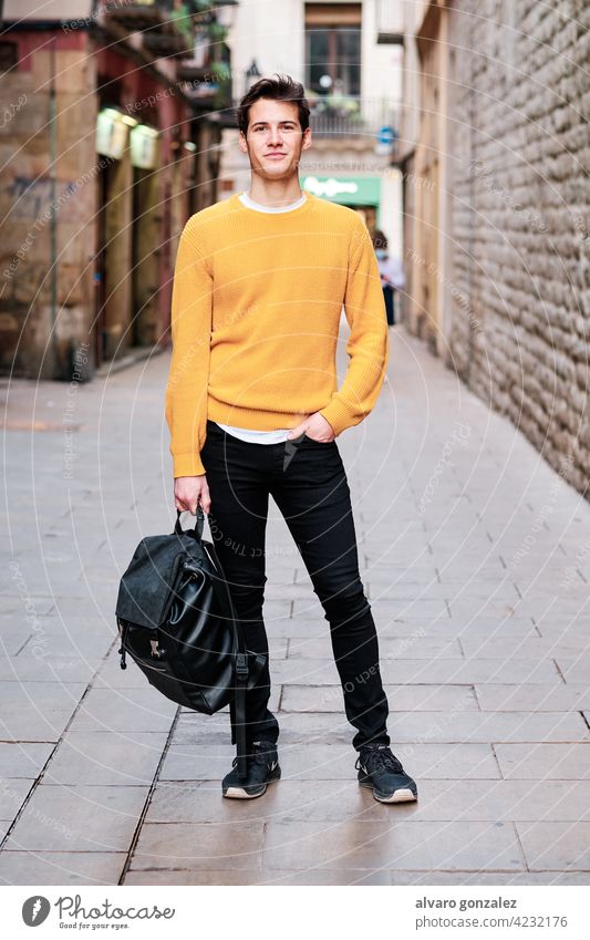 Portrait of young man standing outdoors on the street. portrait urban city confidence backpack posing stylish holding student looking outside confident style