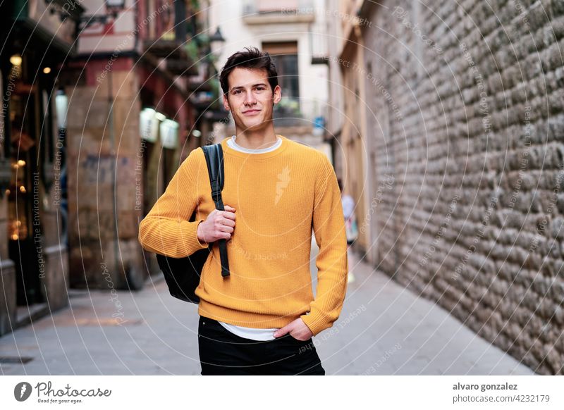 Portrait of young man standing outdoors on the street. portrait urban city confidence backpack posing stylish holding student looking outside confident style