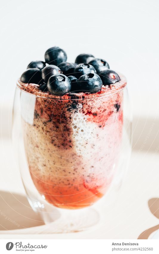 Healthy chia pudding in a glass with fresh blueberries coconut milk almond milk raw breakfast vegan berry blueberry nutrition portion summer sun healthy