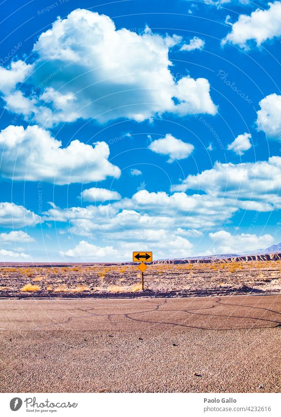Directional sign in the desert with scenic blue sky and wide horizon. Concept for trip, freedom and transportation. Adventure Blue Cloud Desert Empty Freedom