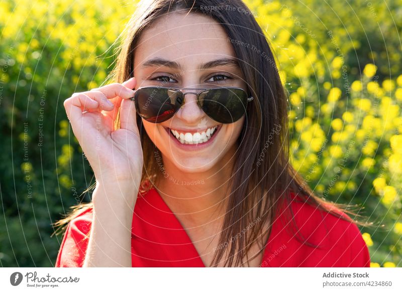 Cheerful woman in modern sunglasses in countryside field fashion style cheerful candid friendly kind portrait sincere accessory creative design natural enjoy