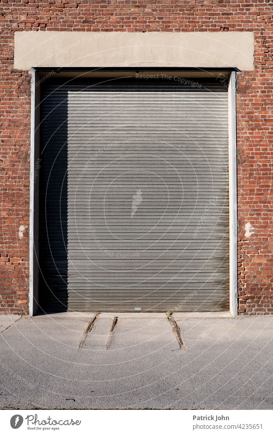 Rolling door in an old industrial hall made of bachstein. Goal Garage door Facade lorry Brick Deserted Building Closed Industrial hall Warehouse