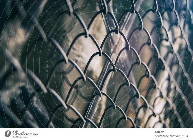 fence with metal grid in perspective chain link background closeup pattern barrier cage iron wall design enclosure old grass construction detail grate macro