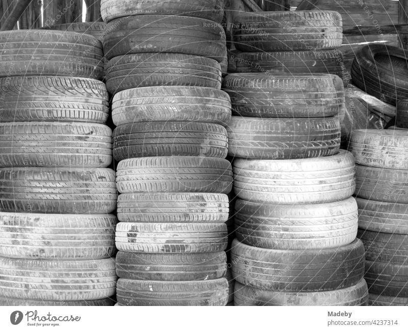 Pile of old car tires in front of a workshop in Adapazari in the province of Sakarya in Turkey, photographed in classic black and white Tire Car tire Rubber