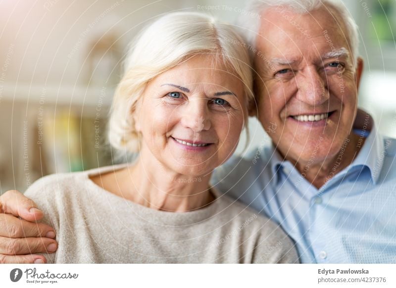 Happy senior couple embracing in their home indoors inside apartment kitchen woman love people together two mature pensioners togetherness retiree retired