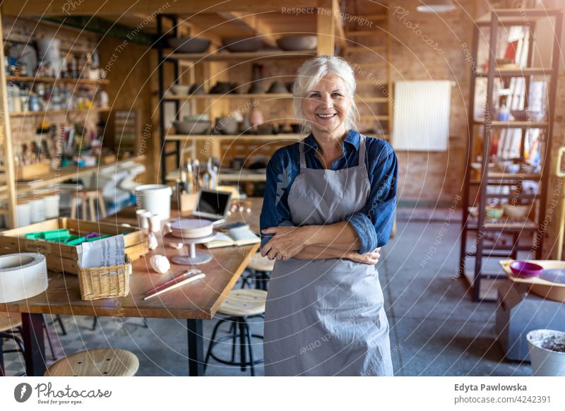 Portrait of senior female pottery artist in her art studio ceramics work working people woman adult casual attractive happy Caucasian enjoying one person