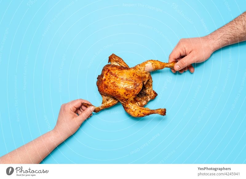 Eating roasted chicken on blue background. People hands grabbing chicken. Sharing food above view baked broiler christmas colored concept consumerism cuisine
