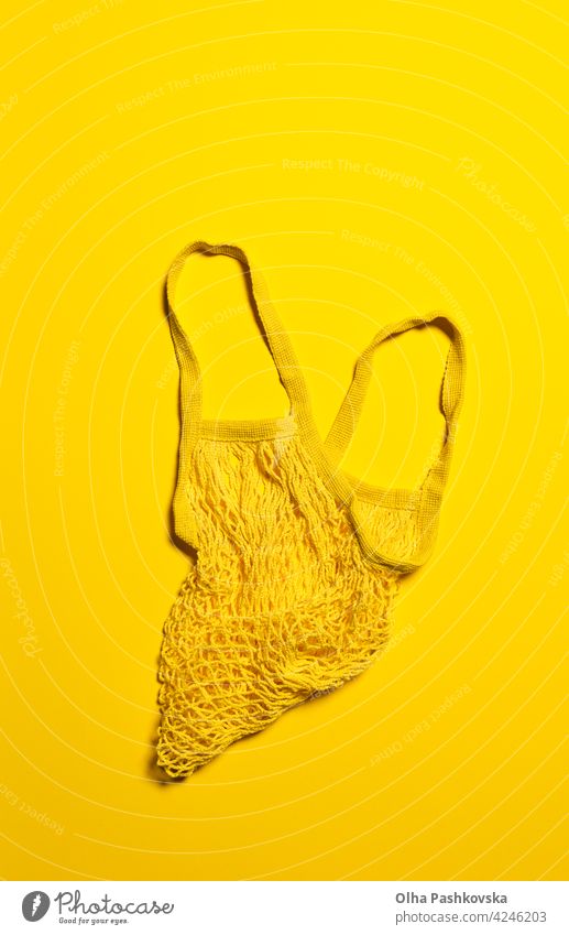 Flat lay with empty yellow mesh bag on yellow bright background flat shopping natural above directly above zero waste reusable plastic eco concept net friendly