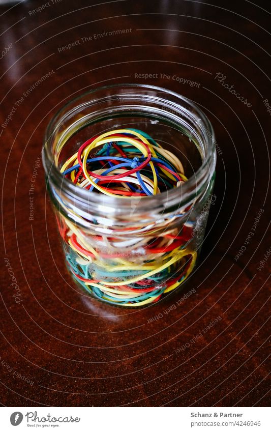 Rubber bands in a jam jar rubber bands amass Collection variegated rubbers Attach garnered Preserving jar Jam jar Rings rubber rings Wooden table Versatile