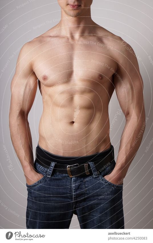 Portrait of shirtless muscular man standing with arms crossed