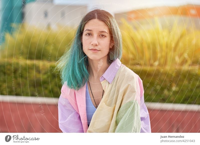 young girl with turquoise hair sitting looking at camera caucasian pensive thinking expression one person emotion lonely relax relaxation emotional ethnicity