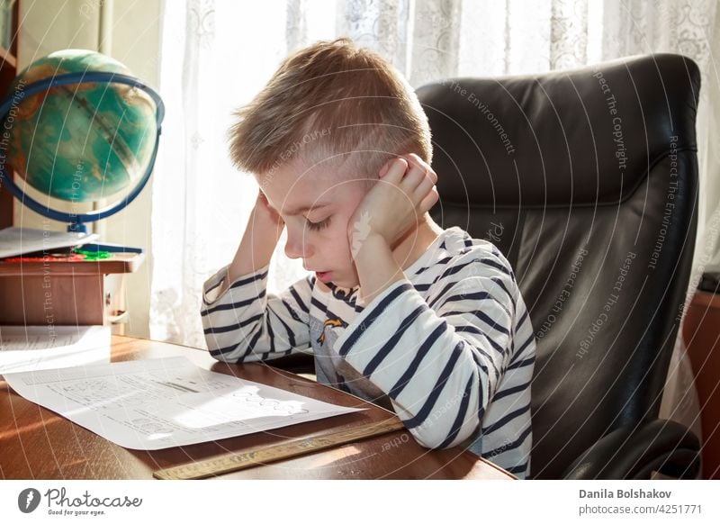 happy boy thinks over the lessons homework doing kid child little alone people person caucasian childhood education study learn school book writing cute