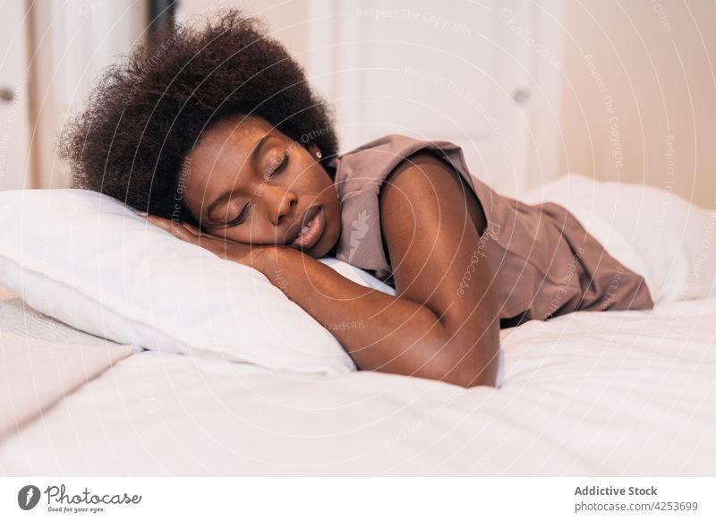 Young black woman sleeping on comfy bed at home eyes closed relax lying bedroom pillow asleep morning calm cozy female young african american ethnic human face