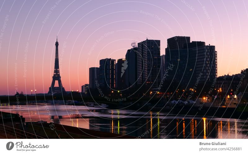 Paris, France. March 07. 2021. The city at sunrise or sunset. View on the quayside of the Seine river. Eiffel Tower in the background. Modern buildings of Beaugrenelle district. Editorial usage only.