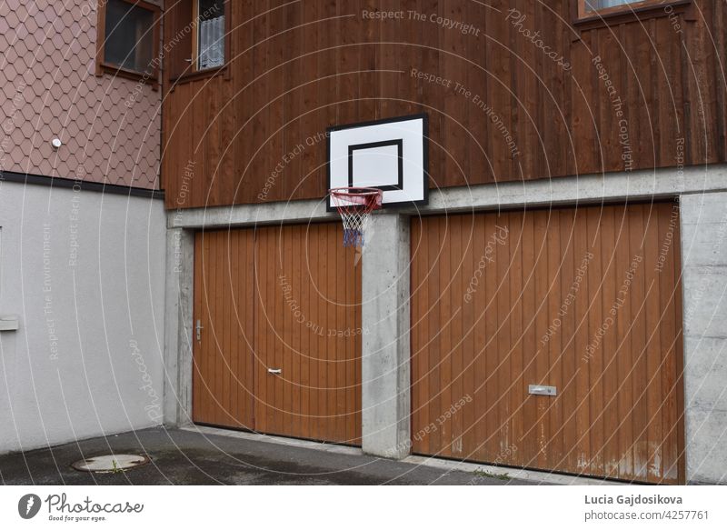 Basketball board and hoop net fixed on the wall of family house over two garage doors. athletic backboard background basketball basketball hoop competition copy