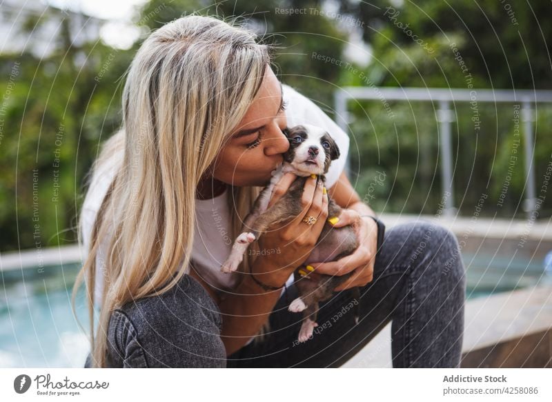 Woman kissing cute purebred puppy on terrace woman embrace border collie dog pet canine charming fondness animal companion serene veranda friendly mammal