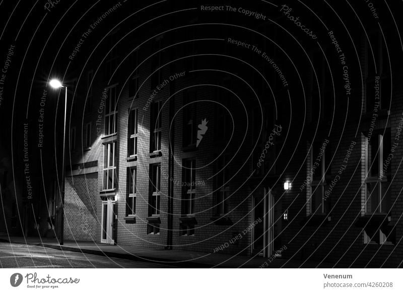 At night on the street,Apartment building is illuminated by street lamp, without people,black and white,Low Key Photography at night streets Building buildings