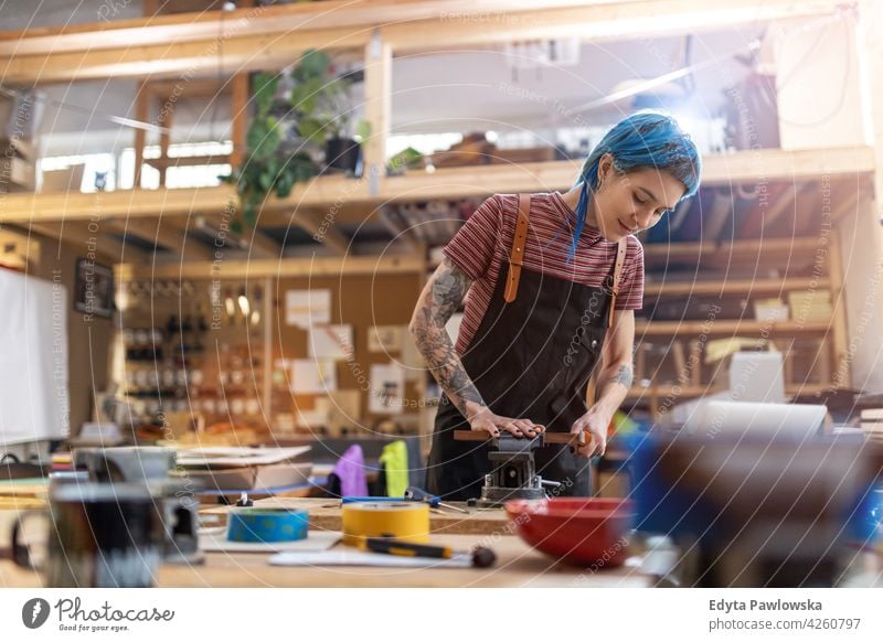 Young craftswoman during her work diy hipster hair tattoos female owner profession service workshop small business employee working workplace maintenance adult
