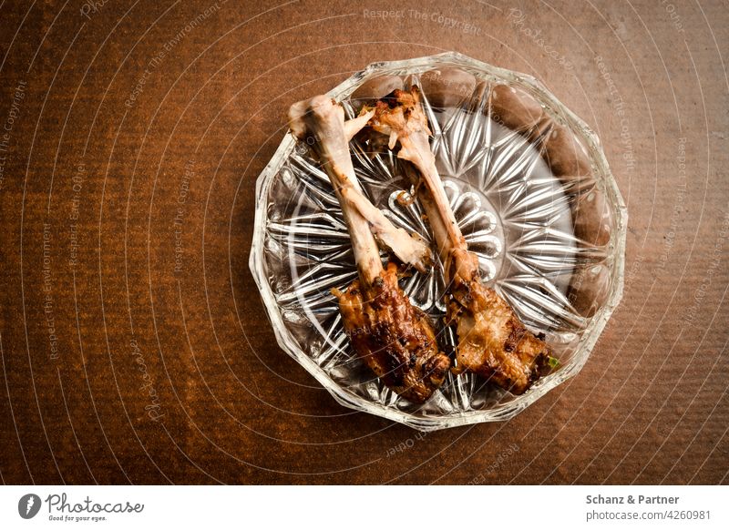 Chicken bones on a cut glass plate Eating Chicken Bones gnaw Food remnants food scraps Glas plate Nutrition Colour photo Meat Organic produce Food photograph