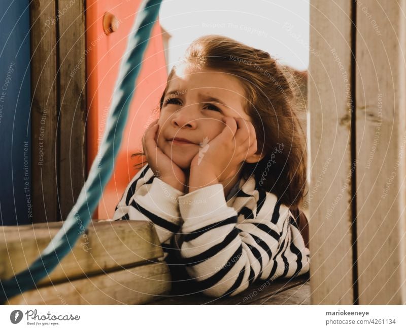 Portrait of a Caucasian little girl with her hands on her face in a pensive attitude innocence think tranquility loneliness real people thoughtful one person
