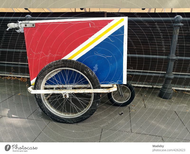 Handcart with spoked wheels and reefer in red and blue in summer at the Binnenalster in the hanseatic city of Hamburg Cart Reefer Cooling tube Rade spoke wheel