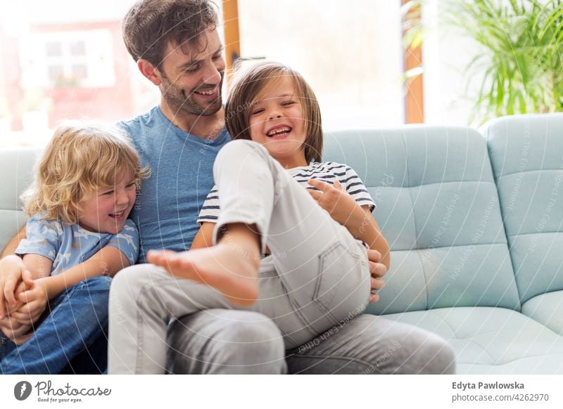 Father playing with his little sons at home man dad father family parents relatives boy kids children relationship together togetherness love people happy