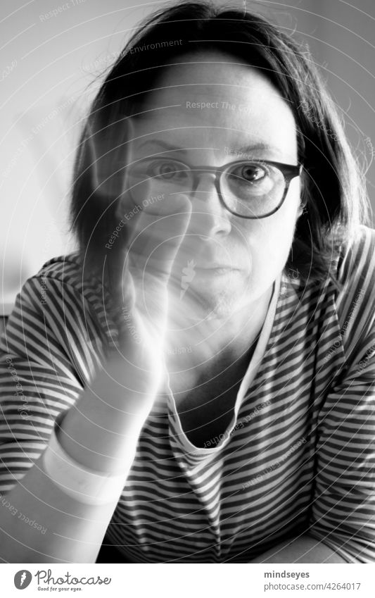 Woman with glasses waves portrait Black & white photo Striped sweater Eyeglasses motion blur Wave waving hand Looking into the camera Forward Earnest Calm