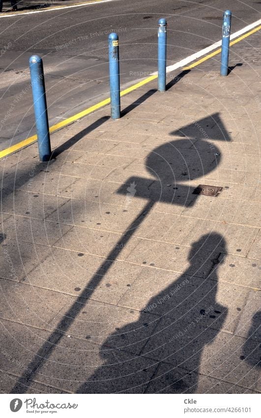Shaded road Shadow Human being street sign Street Signs and markings Signage Passer-by Delimitations Colour photo Road sign Traffic infrastructure Safety lines