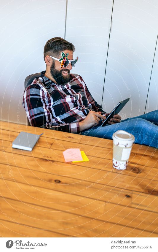 Happy office worker because he goes on vacation happy businessman funny sunglasses tablet smiling holiday start happiness working celebrating beard relaxed