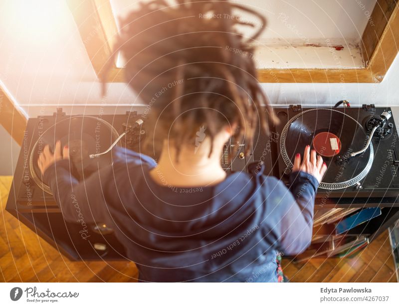 Woman Dj working with vinyl records, overhead view woman young people one person beautiful hair dreadlocks dj mixes turntable music mixing art rear view