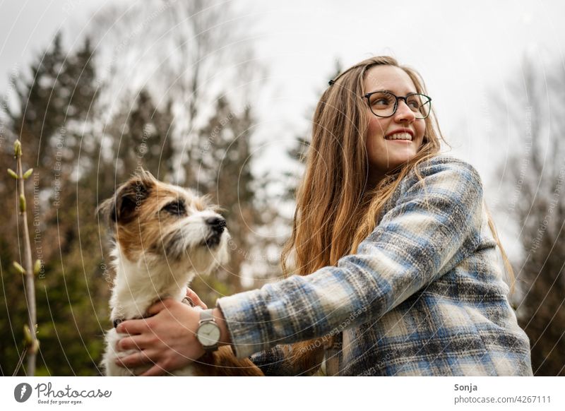 Young smiling woman with glasses and a small dog outside in the park Woman Smiling youthful Dog Terrier Small Park Tree Pet Cute Happy Lifestyle pretty portrait