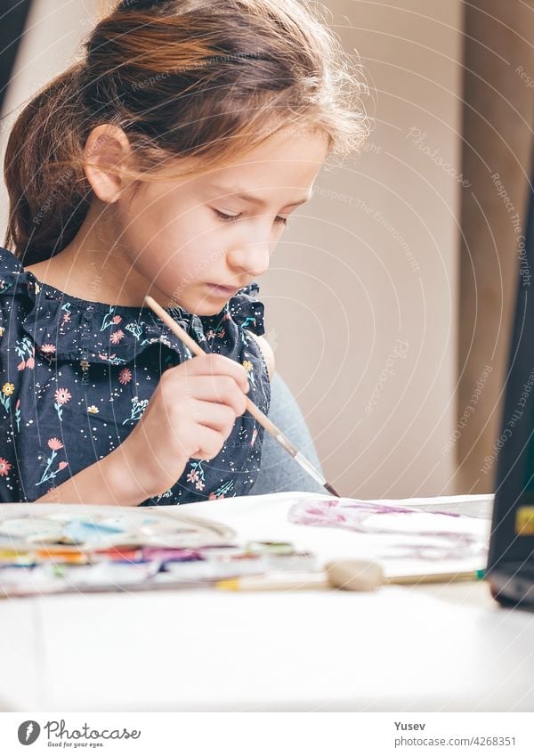Cute lovely girl draws with paints. Ideas for activities with children at home. Vertical shot cute school sitting table drawing color studies ideas learning