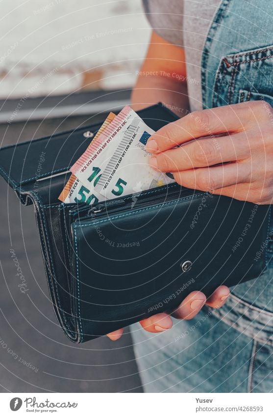 Female hands hold a wallet with euro banknotes. The concept of finance, savings, financial expenses. Close-up. Vertical shot female holding currency economic