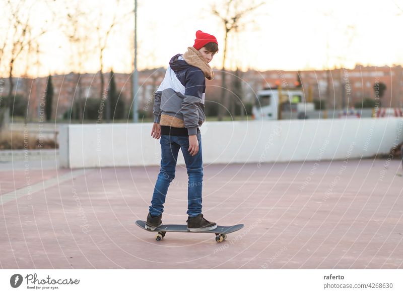 Teenager skateboarder boy with a skateboard on asphalt playground doing tricks. children teenage person sport action cool dynamic guy hipster practice